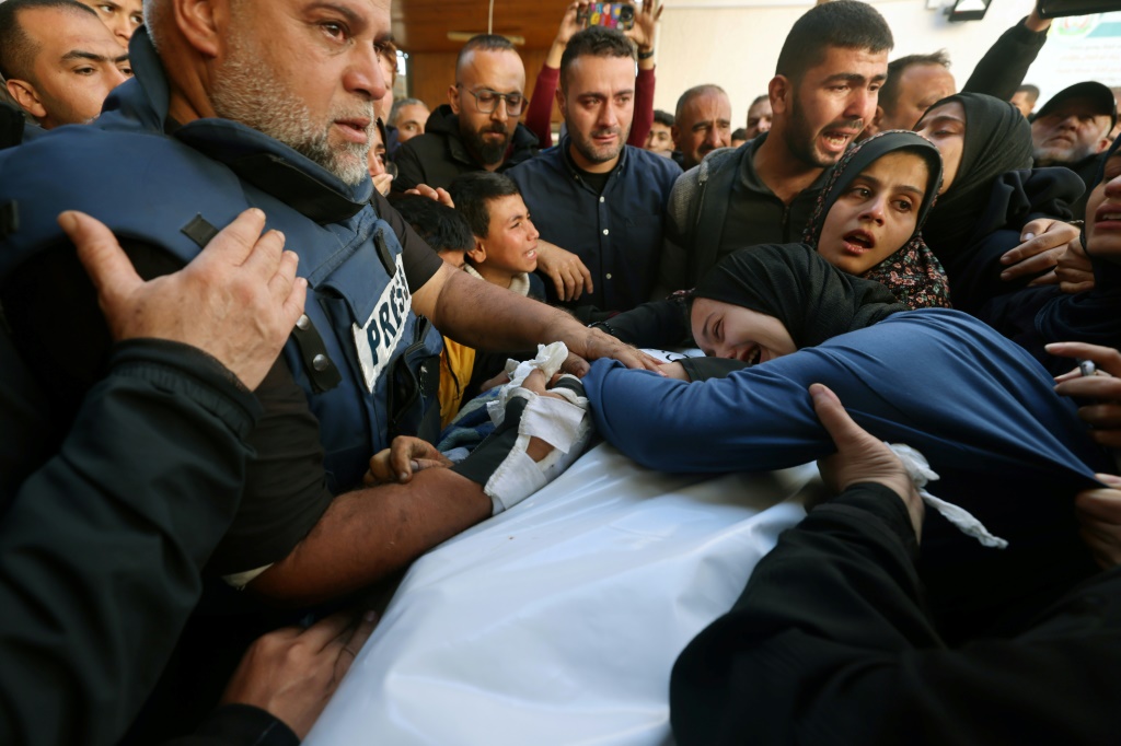 مدير مكتب الجزيرة في غزة وائل الدحدوح يحتضن ابنته خلال جنازة ابنه حمزة الصحافي في شبكة الجزيرة الفضائية الذي قُتل في غارة جوية إسرائيلية على رفح في قطاع غزة في 7 كانون الثاني/يناير 2024 (أ ف ب)   