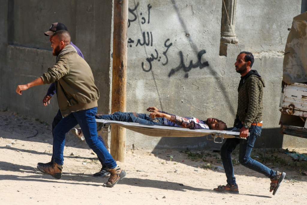 فلسطينيون ينقلون رجلا على حمالة بعد قصف إسرائيلي على مخيم النصيرات وسط قطاع غزة في 12 نيسان/أبريل 2024 (ا ف ب)