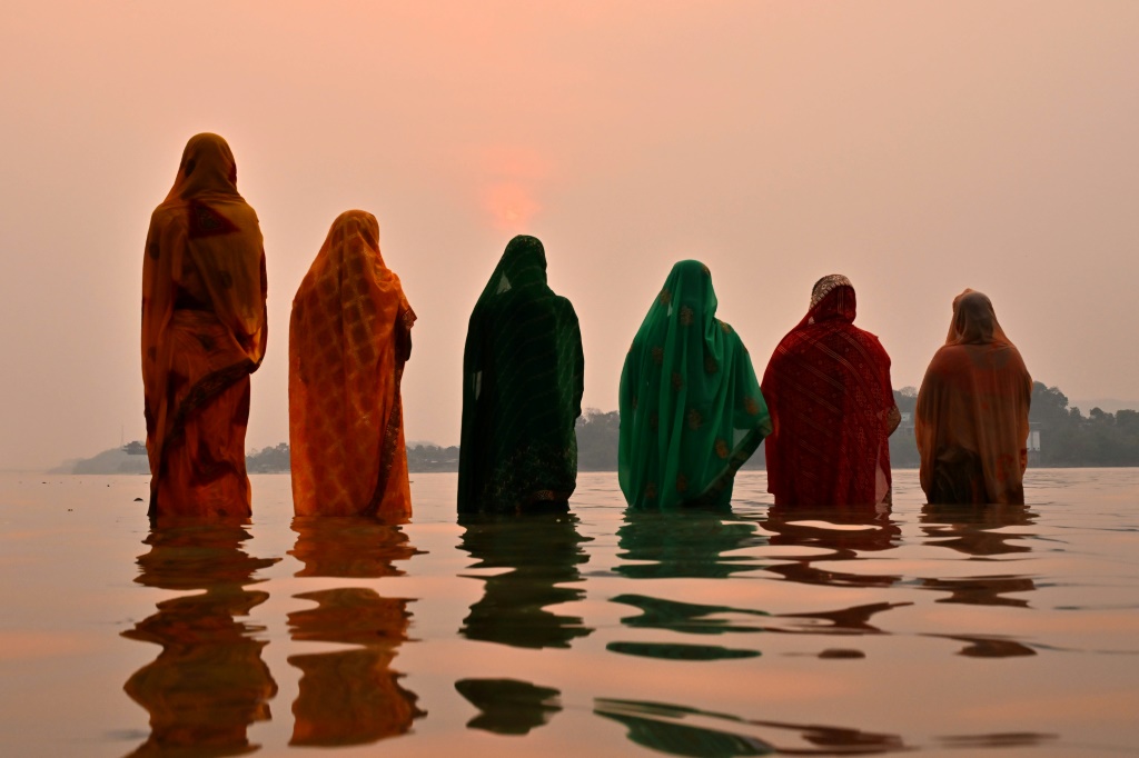 صورة مؤرخة في 14 نيسان/أبريل 2024 لنساء هندوسيات في نهر براهمابوترا خلال مهرجان ديني في غواهاتي (ا ف ب)