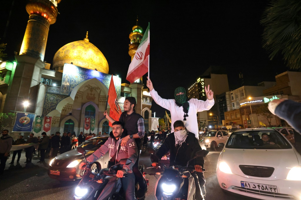 متظاهرون إيرانيون يحتفون بالضربة الإيرانية على إسرائيل في ساحة فلسطين في طهران في 14 نيسان/أبريل 2024 (ا ف ب)
