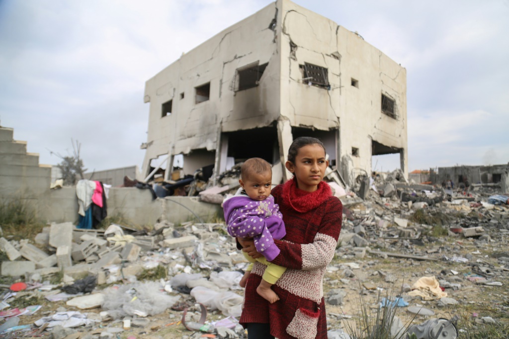 فلسطينيون وسط أنقاض منزل عائلي بعد القصف الإسرائيلي غرب مخيم النصيرات للاجئين وسط قطاع غزة في 16 مارس 2024 (ا ف ب)