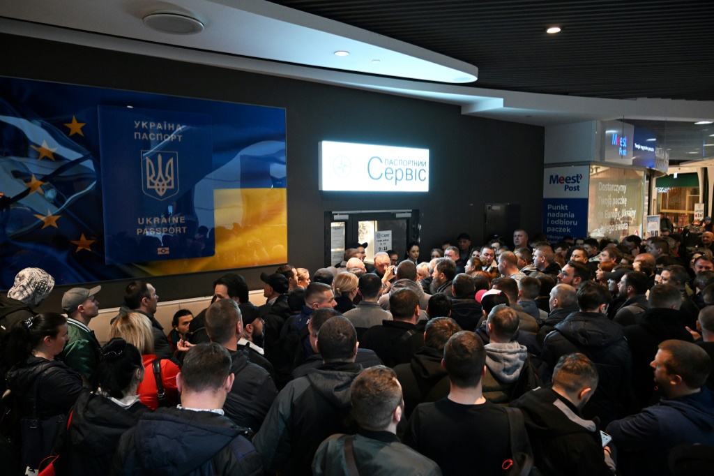    تجمع الأوكرانيون عند نقطة مغلقة لخدمة جوازات السفر الأوكرانية في مركز للتسوق في وارسو يوم الأربعاء في وارسو، وكانوا غاضبين من قرار كييف تعليق الخدمات القنصلية (أ ف ب)   